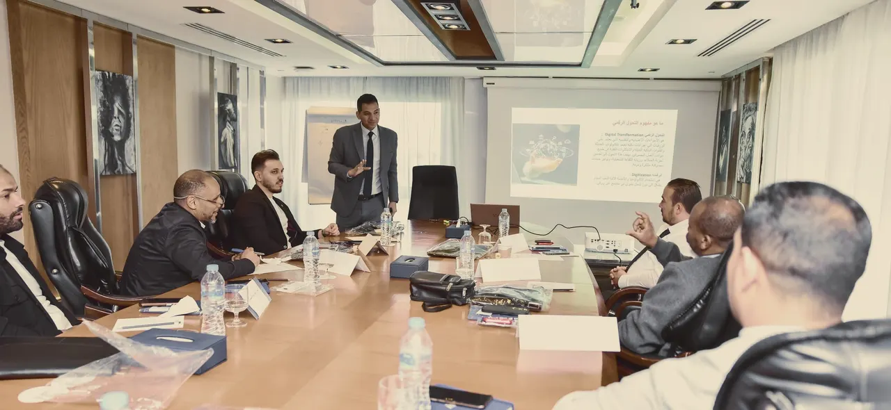 جلسة تدريبية لبرنامج العزب حول طاولة اجتماعات، والمشاركون يتابعون العرض